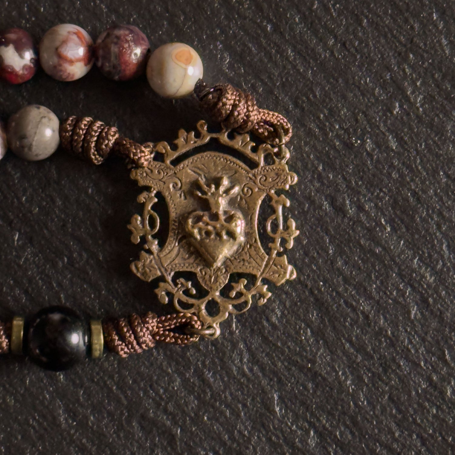 Heirloom Catholic rosary collection with solid bronze crucifixes and natural stone beads on slate