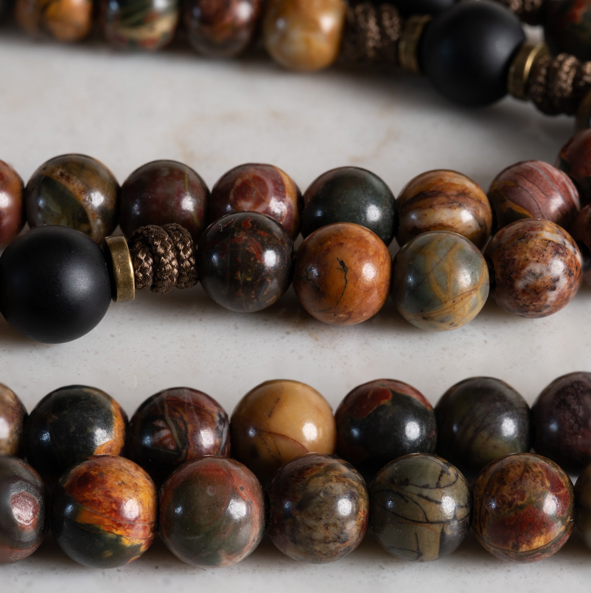 Close-up of Red Creek Jasper and matte Black Onyx beads on the Furnace of Charity rosary